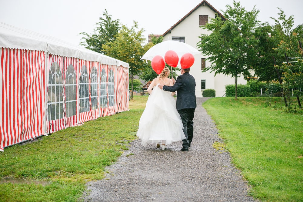 Hochzeit Location Fotograf Cham Aargau Brautpaar neben Festzelt Regen