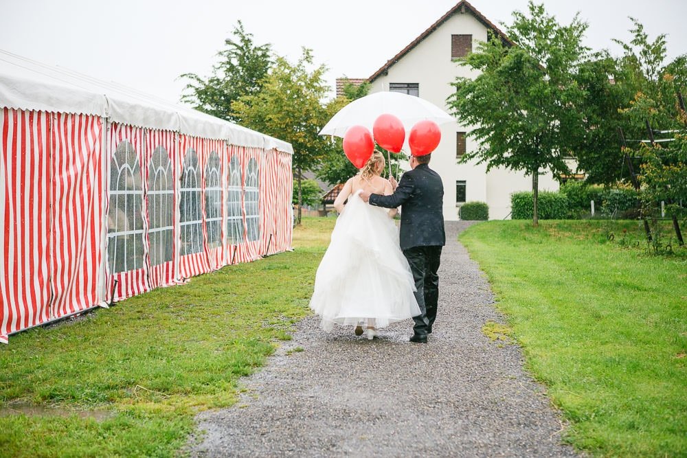 Hochzeit Yvonne & Stefan Hochzeit Location Fotograf Cham Aargau Brautpaar neben Festzelt Regen