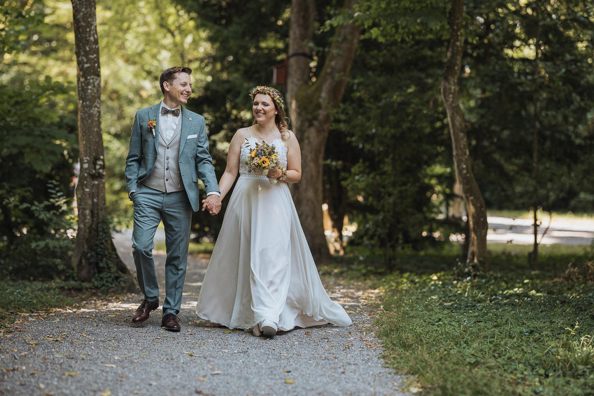 Hochzeit Claudia und Robin Brautpaar spaziert auf Waldweg