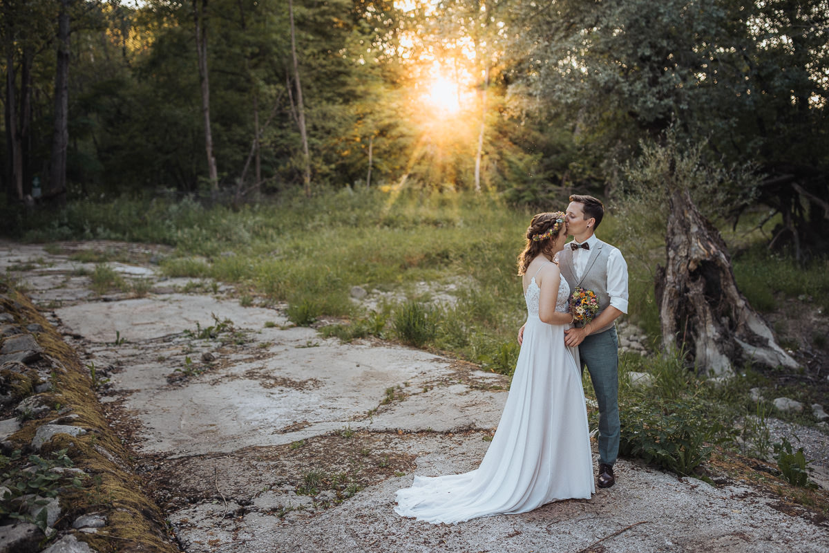 Hochzeit Claudia und Robin Brautpaar Kuss im Wald mit Sonneneinstrahlung